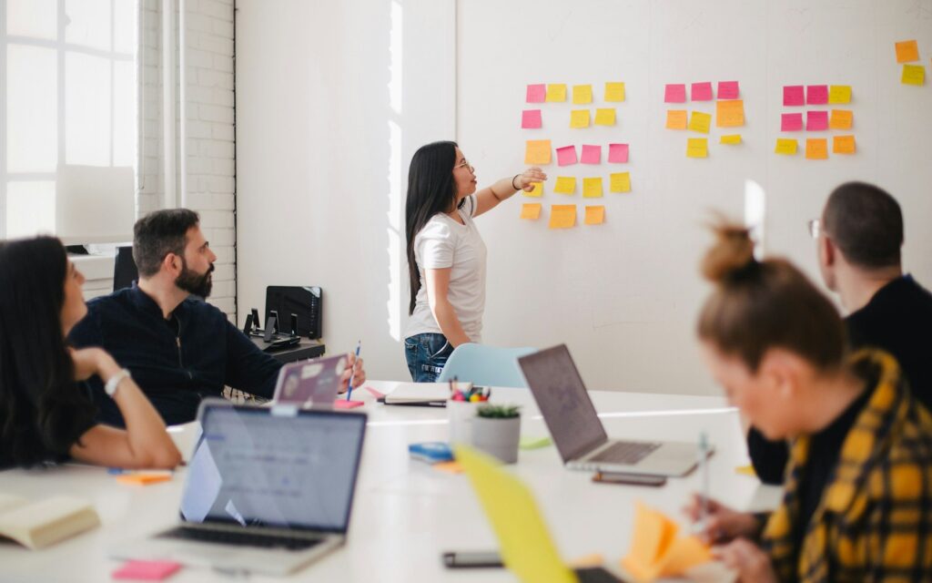Team arbeitet mit Haftnotizen an einer Glaswand – Employer Branding mit echten Einblicken
