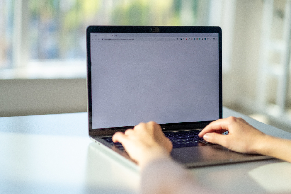 Hände tippen auf einer Laptop-Tastatur