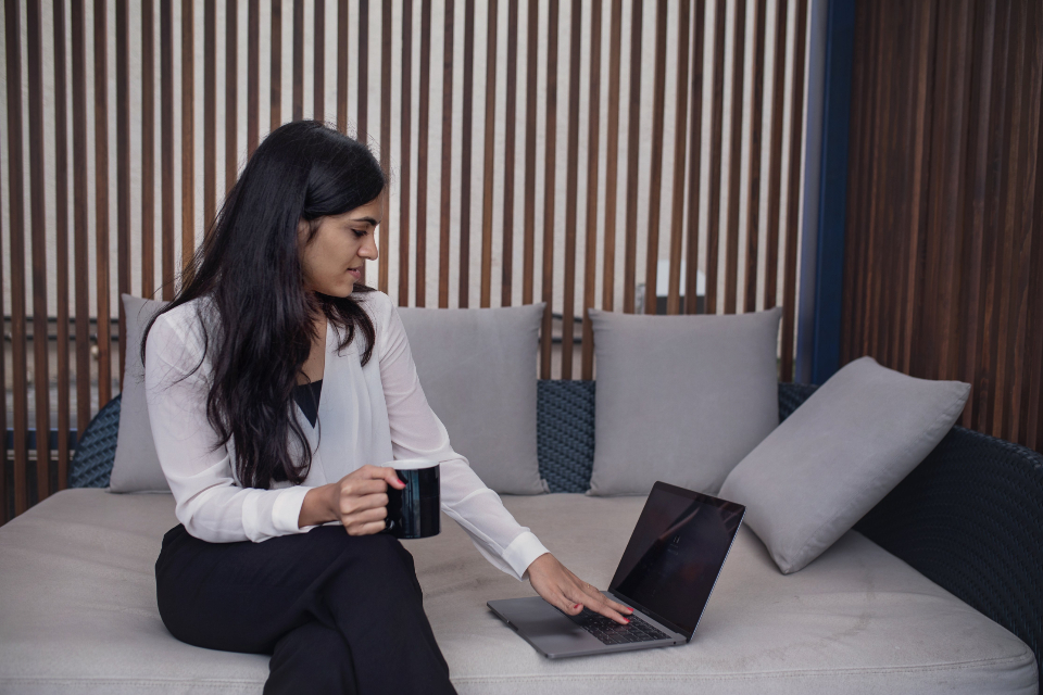 Frau arbeitet am Laptop auf dem Sofa zum Thema BFSG