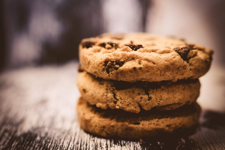 Gestapelte Kekse auf einem Holztisch als Symbol für das Cookie-Banner