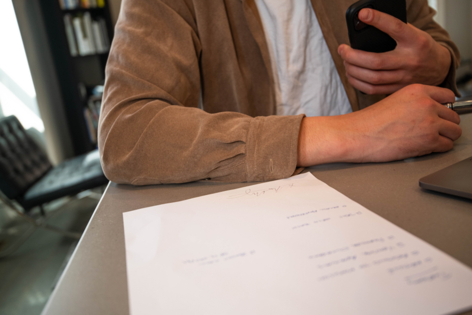 Person prüft ein Schriftstück am Schreibtisch