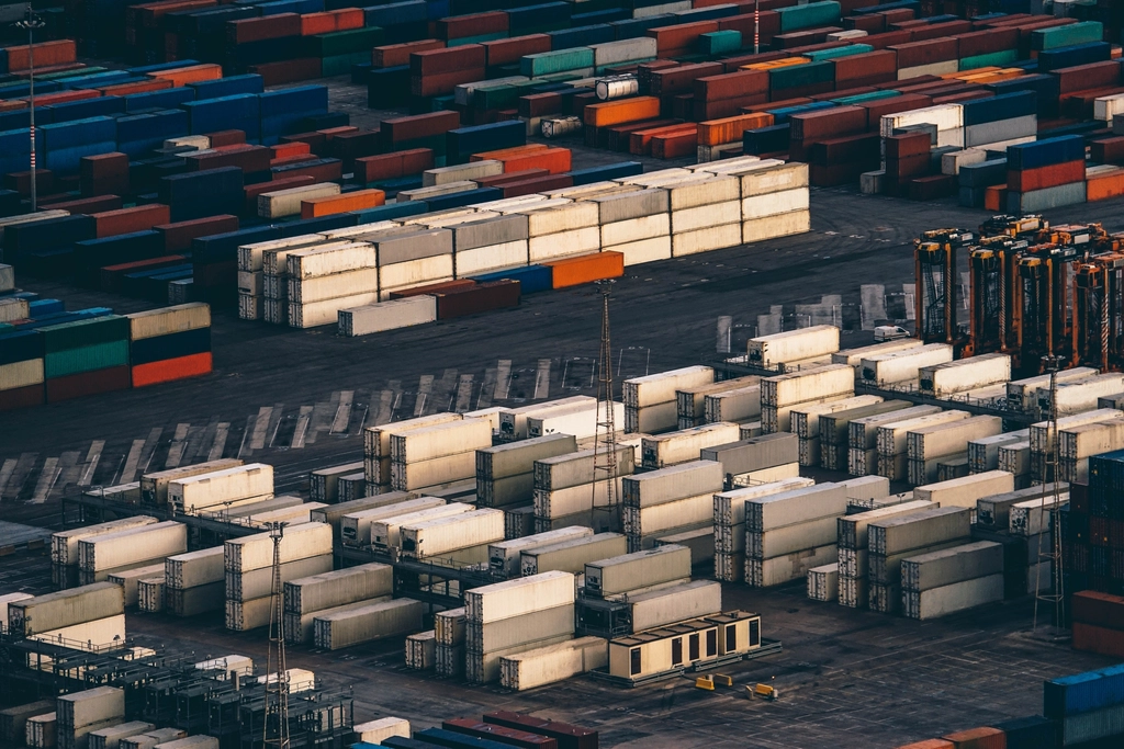 Gestapelte Schiffscontainer im Hafen zum Thema Expansion ins Ausland