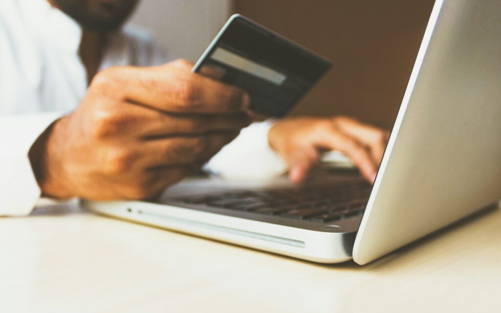 Kreditkarte vor einem Laptop als Symbol für Unternehmensfinanzierung mit Factoring, Leasing und Kredit