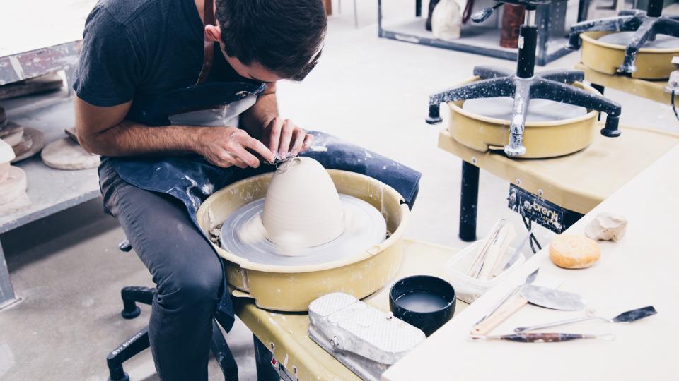 Handwerker arbeitet konzentriert an der Töpferscheibe zum Thema Generationenwechsel