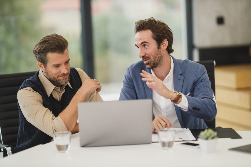 Zwei Gründer besprechen sich am Laptop