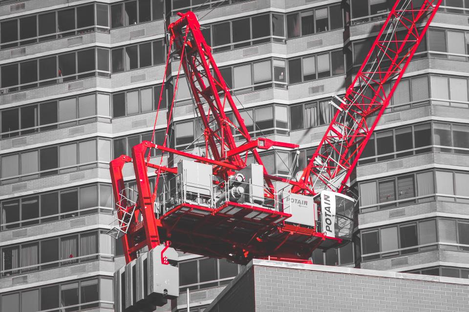 Roter Baukran vor einem Hochhaus