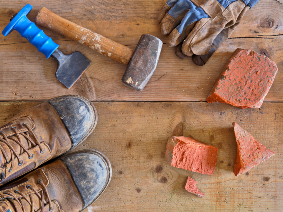 Werkzeug, Arbeitsschuhe und Ziegelsteine auf einer Baustelle zum Thema Google Unternehmensprofil