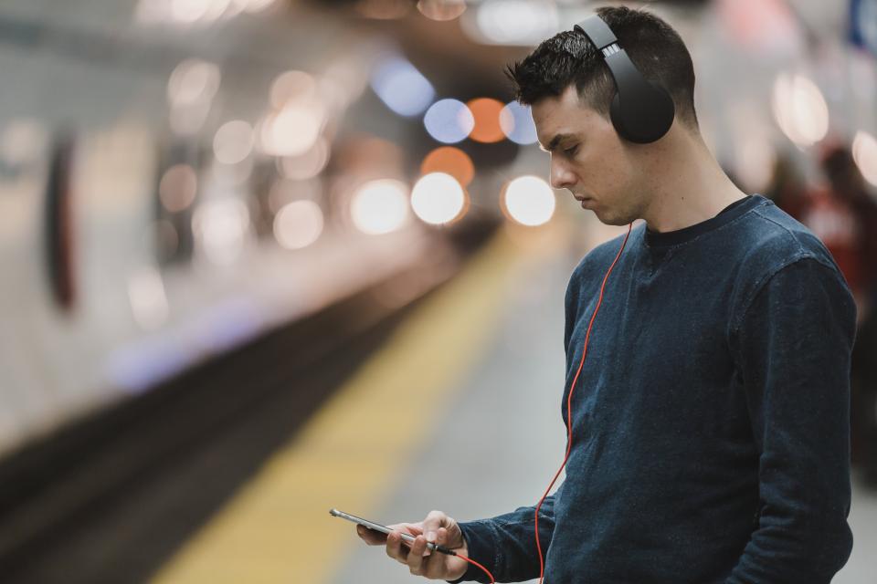 Pendler wartet mit Kopfhörern am Bahnsteig zum Thema Jobticket