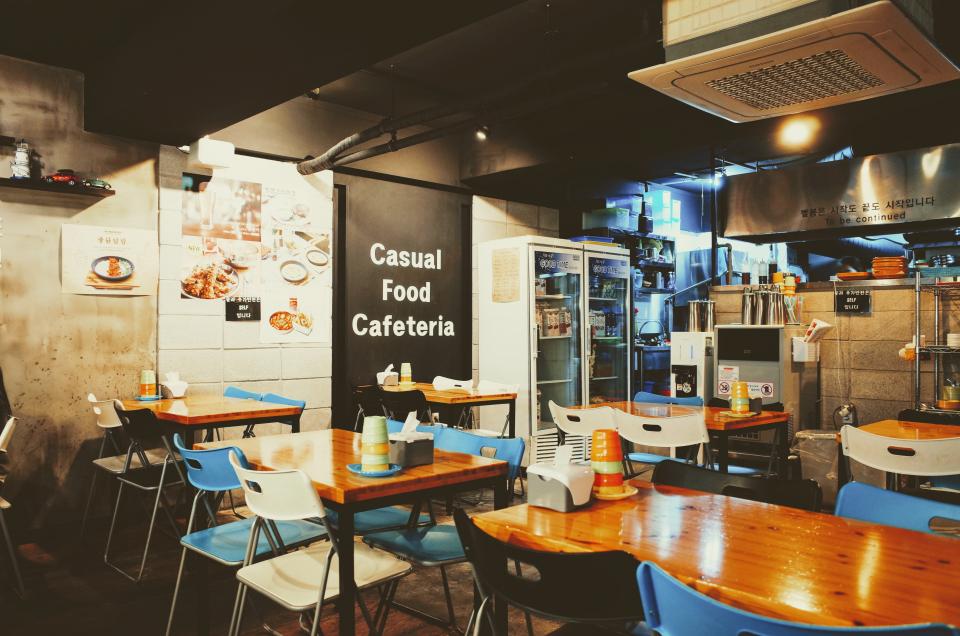 Gastraum einer Cafeteria mit Tischen und Theke