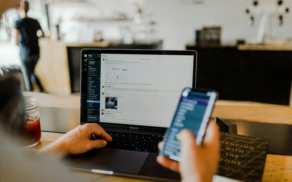 Person mit Laptop und Smartphone – Kontakt zur Redaktion