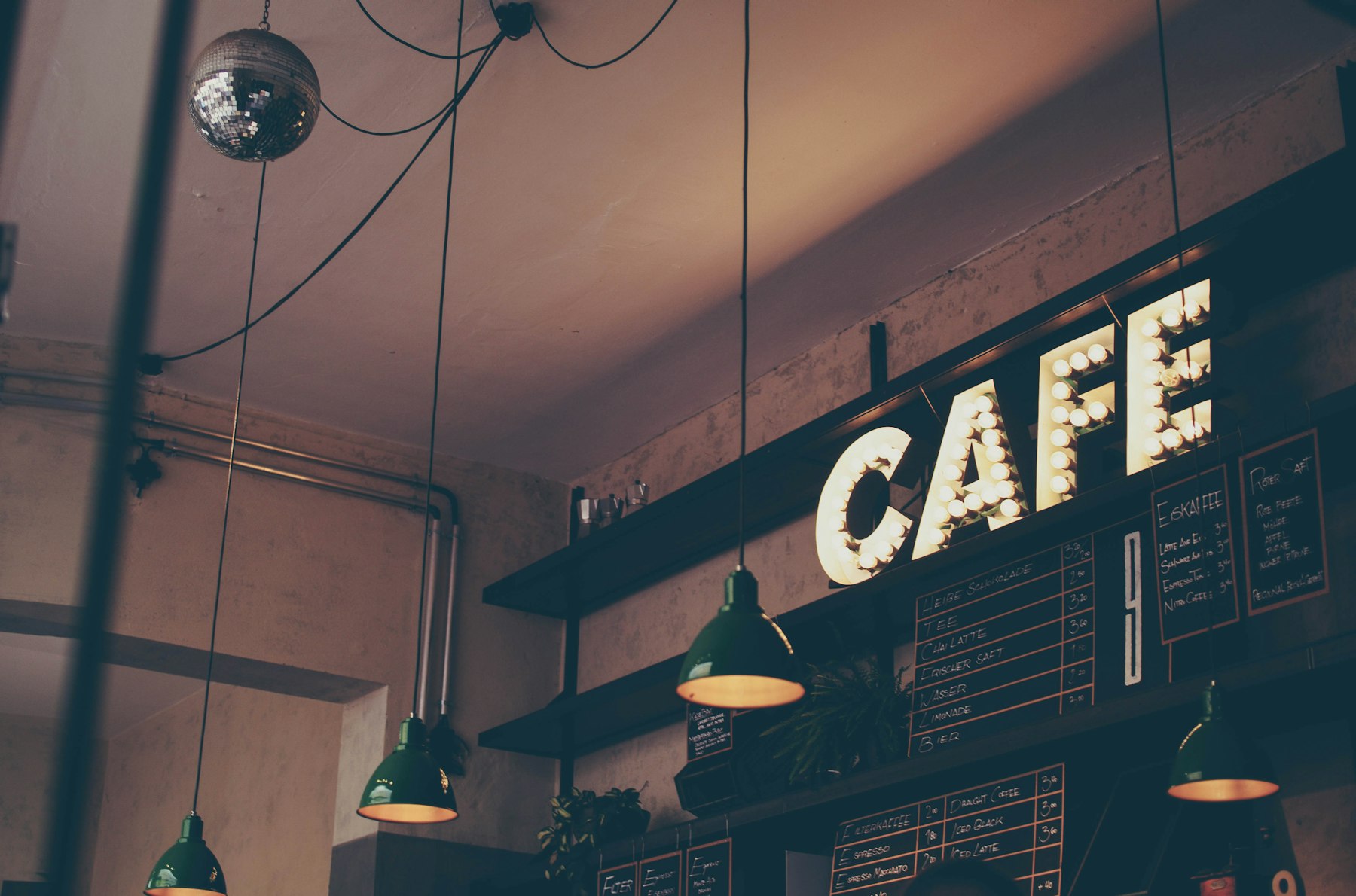 Leuchtschrift Cafe an einer Backsteinwand in einem Lokal