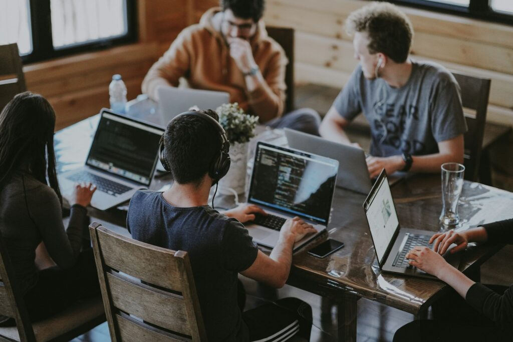 Team arbeitet gemeinsam an Laptops als Symbol für starke Mitarbeiterbindung