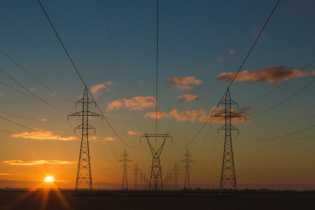 Strommasten im Sonnenuntergang als Symbol für Netzentgelte im Gewerbe