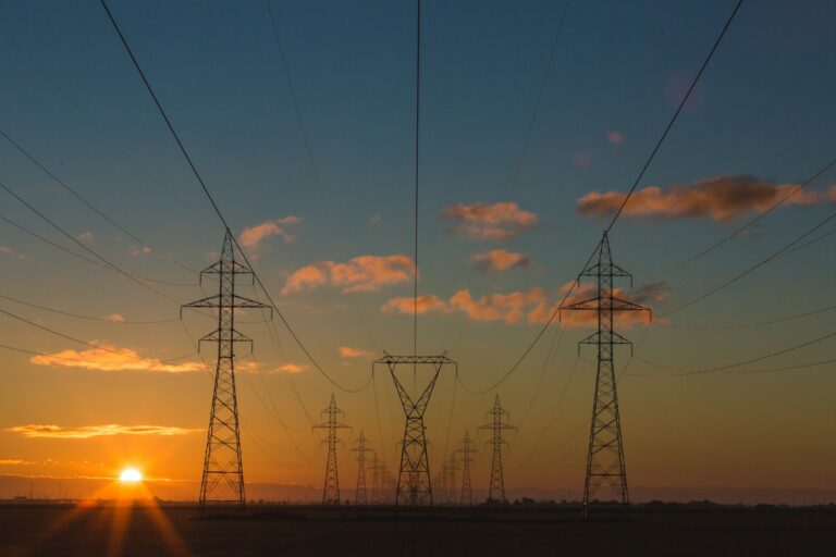 Strommasten im Sonnenuntergang als Symbol für Netzentgelte im Gewerbe