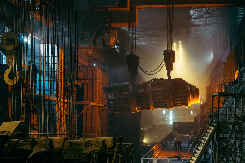 Stahlwerk mit Kran und glühendem Metall zum Thema Netzentgelte