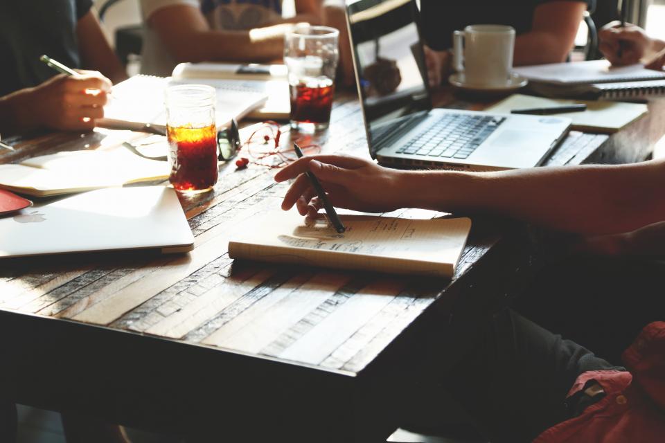 Arbeitstisch eines Teams mit Laptop und Notizen zum Thema Onboarding Checkliste