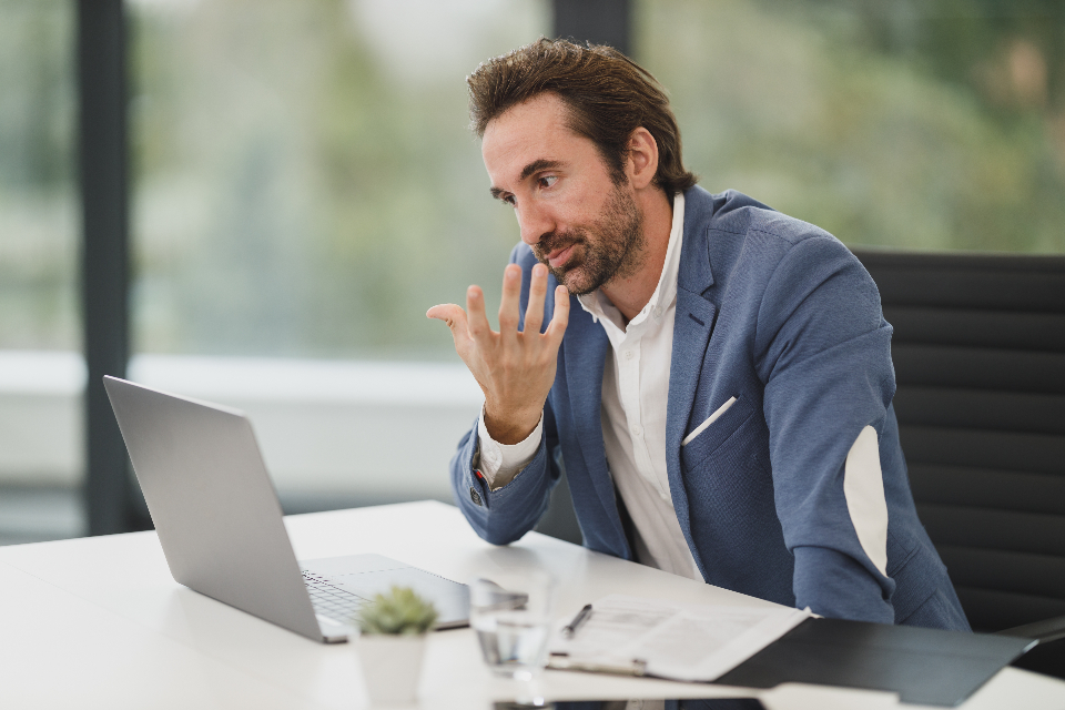 Mann im Videogespräch am Laptop zum Thema Remote Leadership