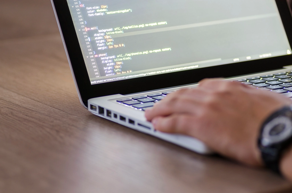 Hände tippen auf einem Laptop bei der Auswertung von Shopdaten