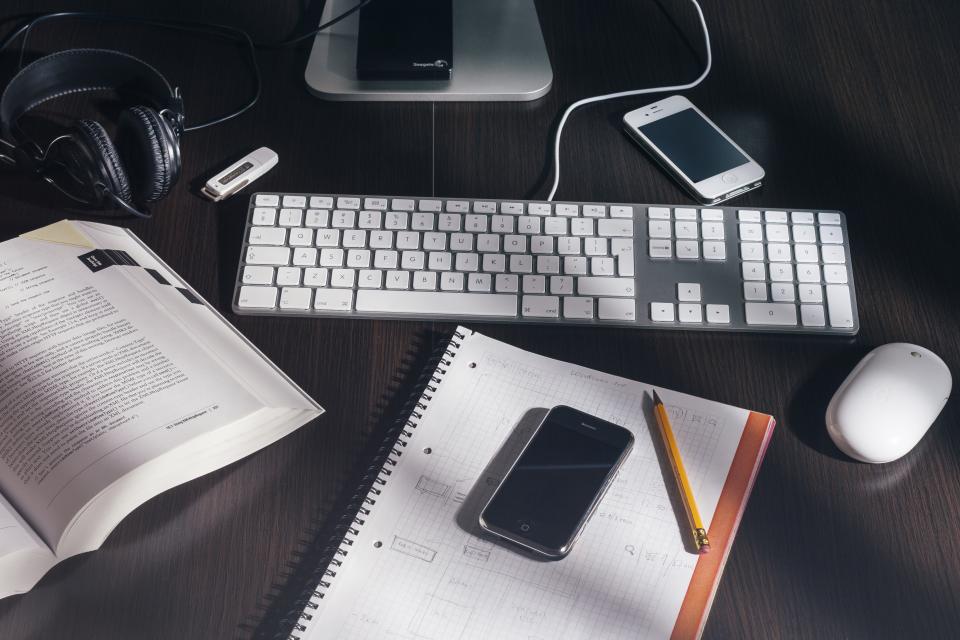 Schreibtisch mit Tastatur, Smartphone und Unterlagen zum Thema Verfahrensdokumentation