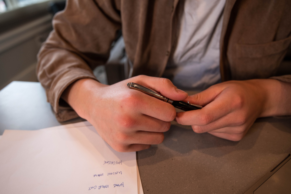 Hände mit Stift über einem Schriftstück zum Thema Rechnungen aufbewahren
